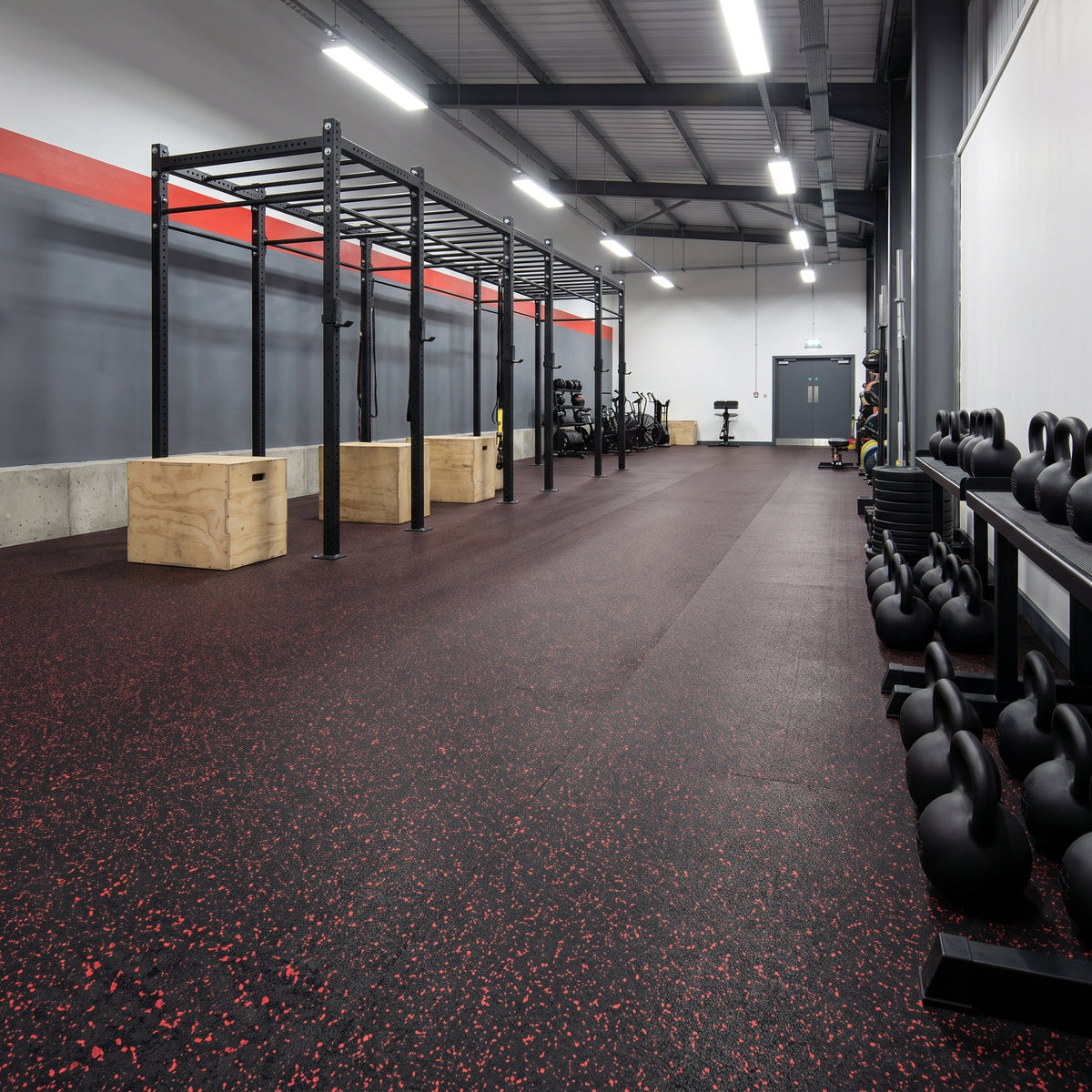 Red Fleck rubber gym flooring rolls professionally fitted in a commercial gym functional training area