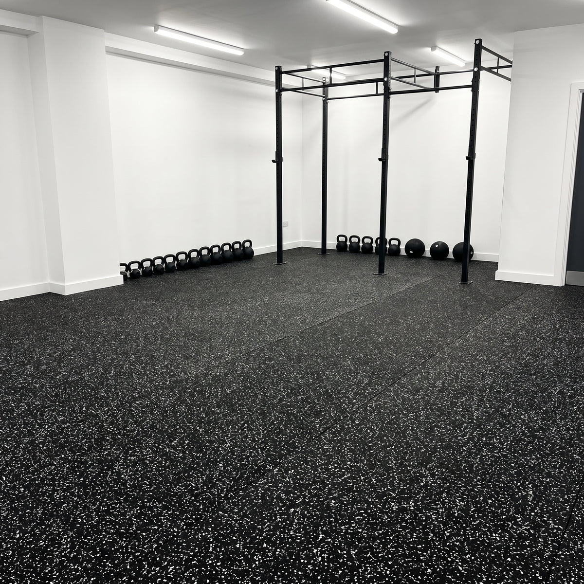 White Fleck rubber gym flooring rolls professionally fitted in a commercial gym with a pull-up rig