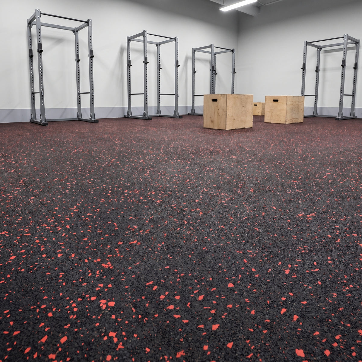Red fleck commercial rubber matting professionally fitted wall-to-wall in a commercial gym free-weights area