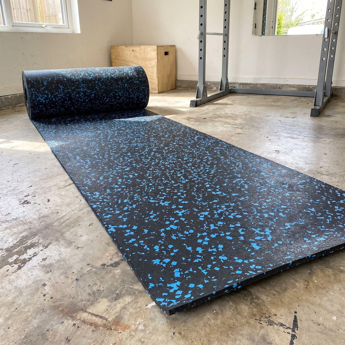 Commercial rubber matting roll in Blue fleck – black rubber with blue flecks, partly unrolled in a home garage gym