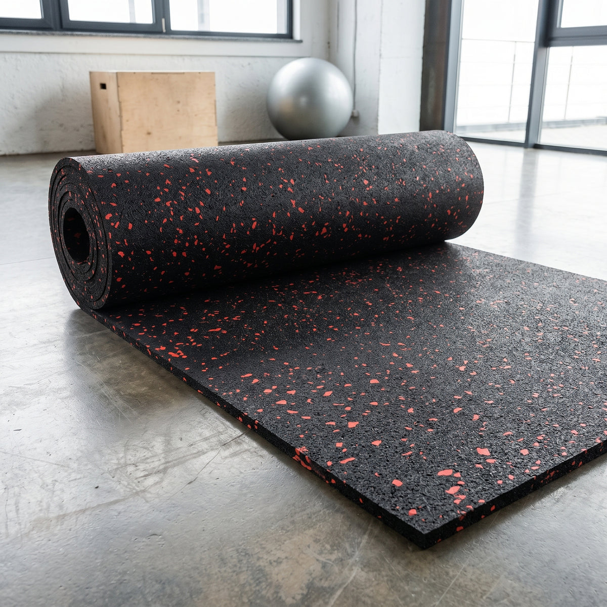 Commercial rubber matting roll in Red fleck – black rubber with red flecks, partly unrolled in a gym