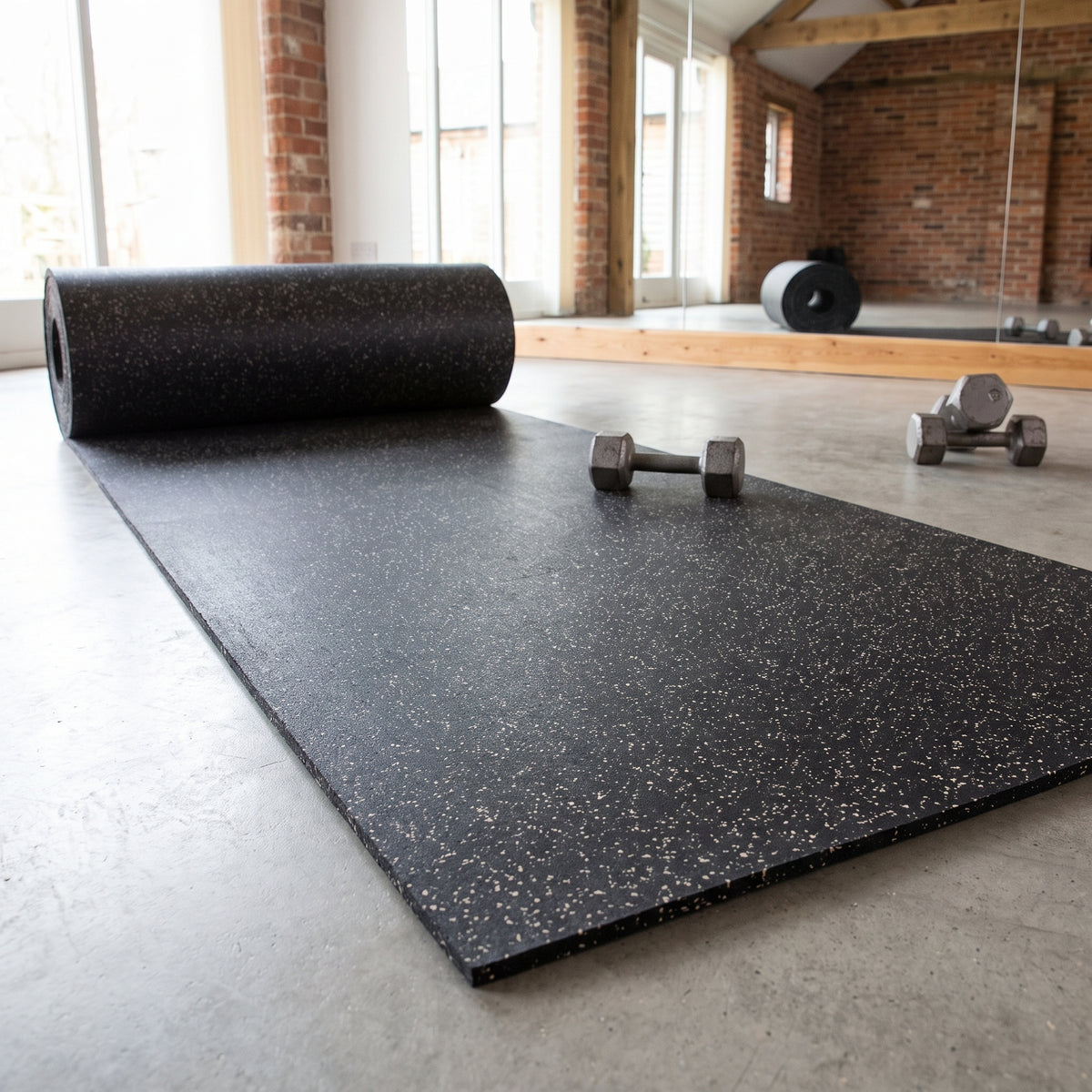 Commercial rubber matting roll in White fleck – black rubber with white flecks, partly unrolled in a fitness studio