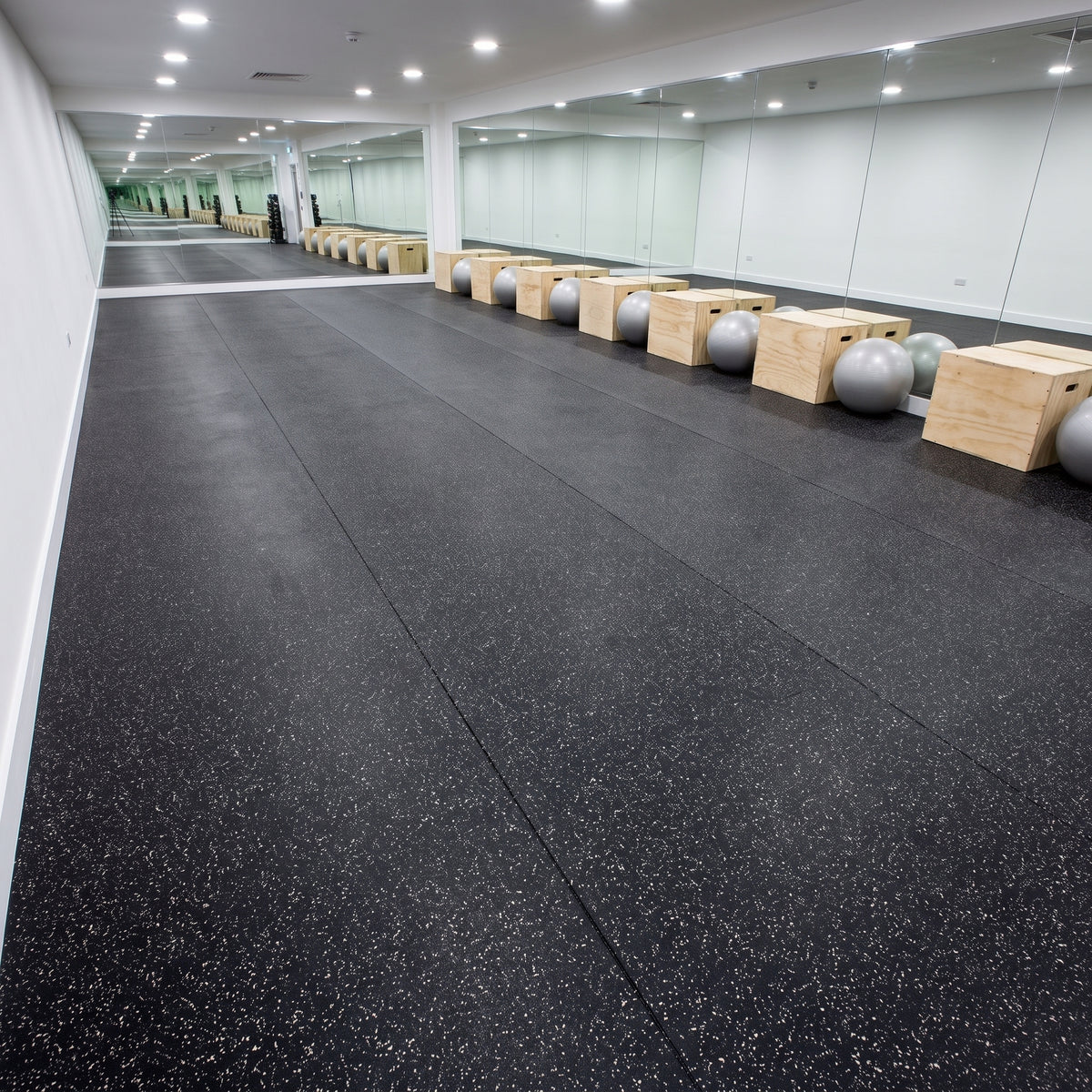White fleck commercial rubber matting professionally fitted wall-to-wall in a commercial gym studio