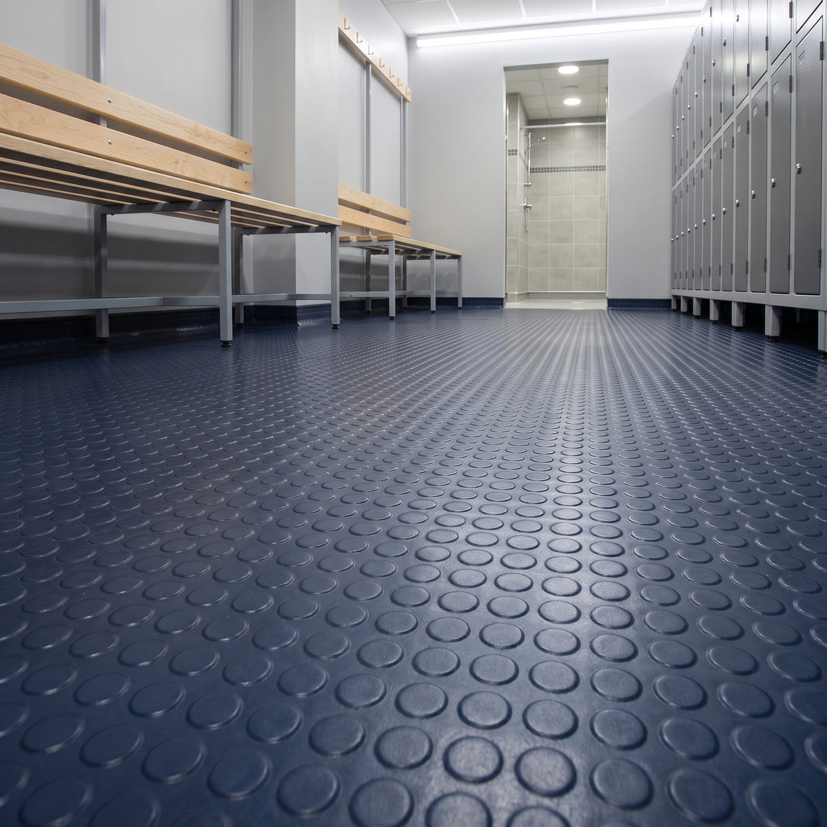Deep Sea Blue studded penny dot rubber flooring roll in a real-world installed setting