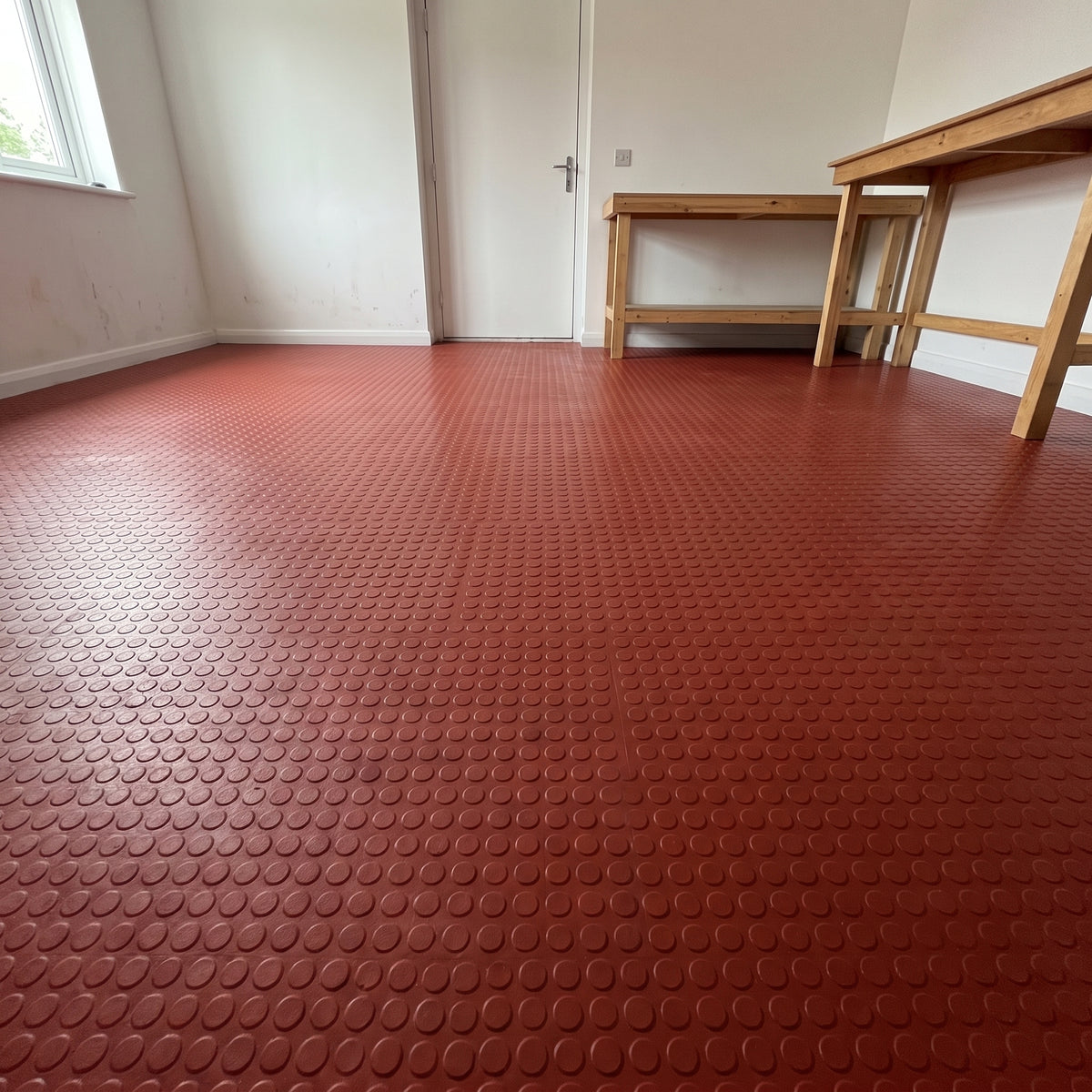Sunrise Red penny dot rubber flooring fitted in a garage workroom