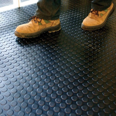Black penny dot rubber flooring with work boots - non-slip surface